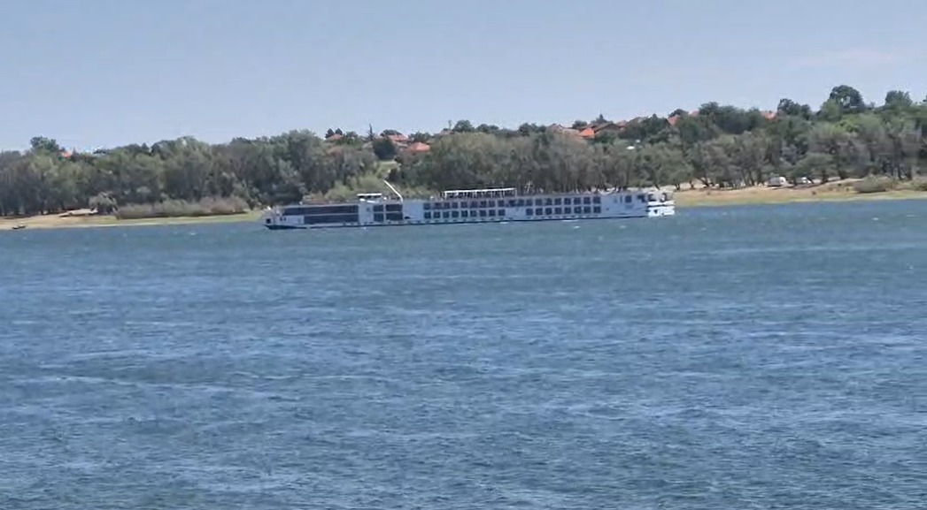 Navă de croazieră pe râu lângă mal împădurit