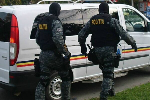Doi polițiști mascați lângă dubă Poliția