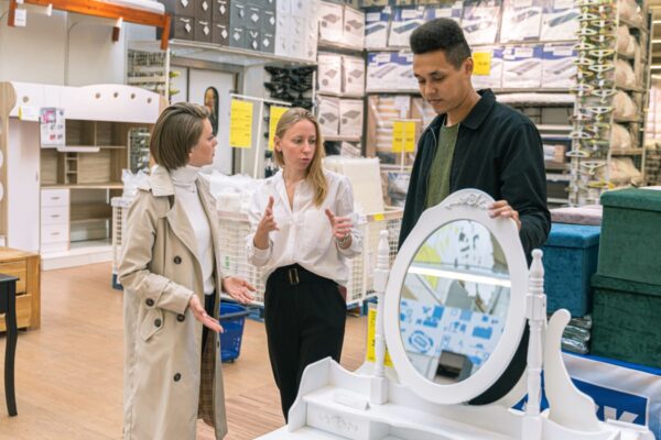 Clienți aleg oglindă albă într-un magazin de mobilier